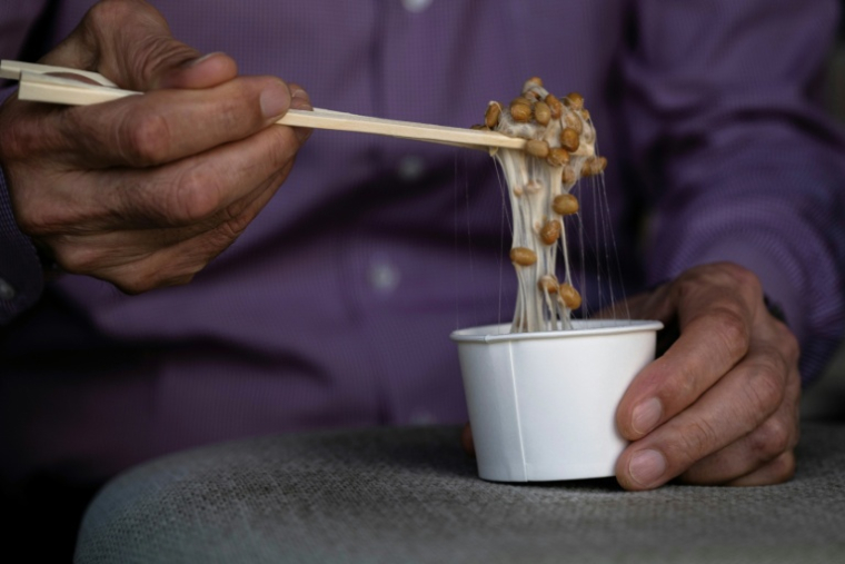Yoshihiro Noro, propriétaire de l'usine de production de  kamakurayama natto, mélange un natto dans son magasin de Kamakura, à une cinquantaine de km au sud-ouest de Tokyo, le 15 mai 2026  ( AFP / Andrew CABALLERO-REYNOLDS )