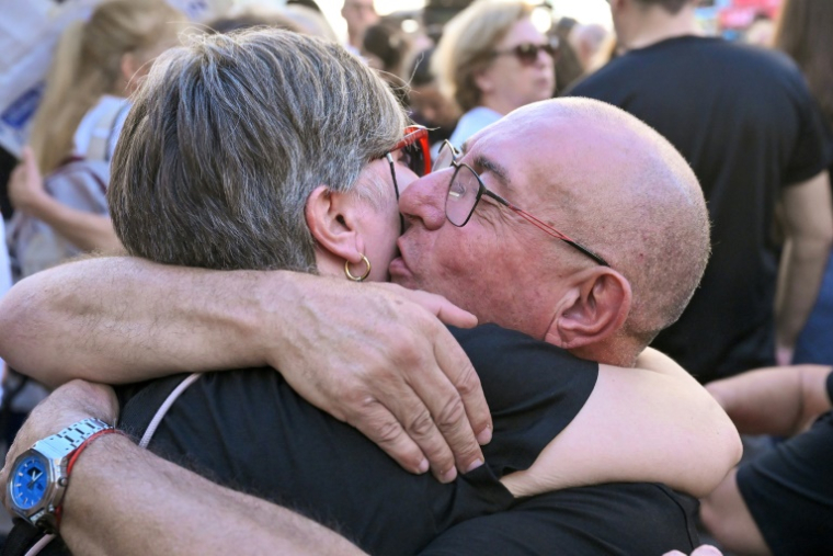 Des membres des familles des victimes des inondations meurtrières de l'année dernière s'étreignent lors d'une marche organisée à Valence le 25 octobre 2025 pour commémorer le premier anniversaire des inondations et exiger que les responsables rendent des comptes ( AFP / Jose JORDAN )