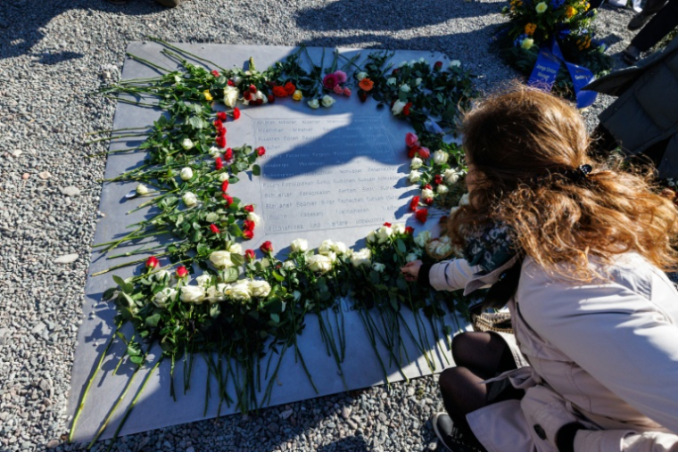 Des pesonnes déposent des fleurs lors de la commémoration du 80e anniversaire de la libération du camp de concentration nazi de Buchenwald, sur le site commémoratif du camp, près de Weimar, le 6 avril 2025 en Allemagne ( AFP / JENS SCHLUETER )
