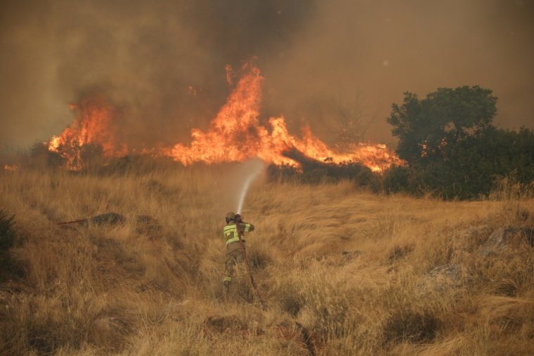 Un pompier tente d'éteindre un feu qui fait rage dans la région de Megara, au nord-ouest d'Athènes, le 3 août 2026. ( AFP / Aris Oikonomou )