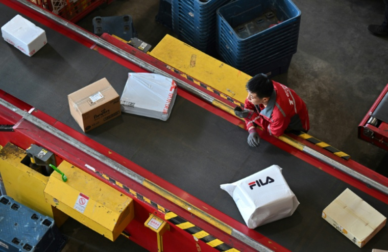 Un employé trie des colis dans un entrepôt de JD.com lors de la "Fête des célibataires", événement commercial annuel majeur en Chine, le 11 novembre 2025 à Pékin ( AFP / Adek BERRY )