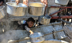 Un garçon palestinien tend une casserole vide devant une organisation de charité locale distribuant du riz cuit, dans la ville de Gaza, le 23 août 2025 ( AFP / Omar AL-QATTAA )