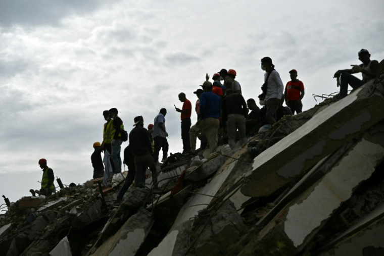 Des secoursites et volontaires sur les décombres d'un immeuble à Caraballeda au Venezuela le 3 juillet 2026 ( AFP / MARTIN BERNETTI )