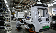 Des ouvriers travaillent sur une ligne de production de l'usine Neolix qui fabrique de petits véhicules utilitaires autonomes pour le transport de colis en ville, le 4 décembre 2025 à Yancheng dans la province chinoise du Jiangsu  ( AFP / Jade GAO )