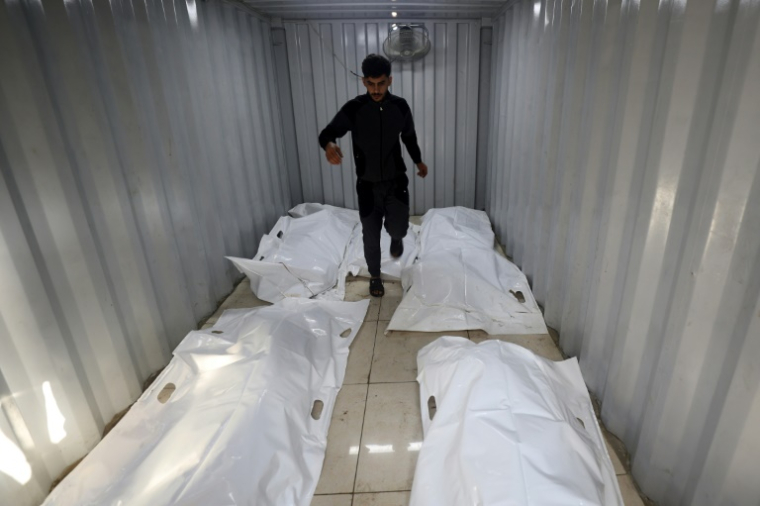 Des corps de victimes dans des sacs blancs à même le sol dans un hôpital du camp de réfugiés de Nouseirat, dans le centre de la bande de Gaza, le 27 septembre 2025 ( AFP / Eyad BABA )