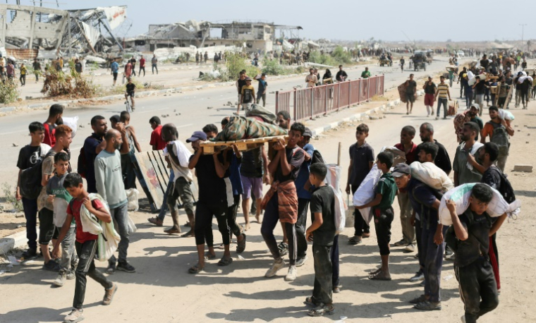Des Palestiniens portent le corps d'un homme tué lors d'une distribution d'aide humanitaire près du camp de réfugiés de Nousseirat, dans le centre de la bande de Gaza, le 2 août 2025 ( AFP / Eyad BABA )