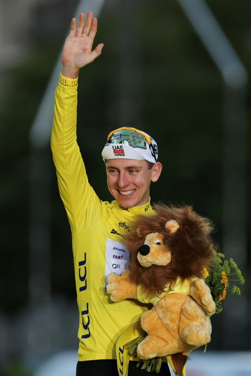 Le maillot jaune slovène Tadej Pogacar tout sourire sur le podium pour célébrer son cinquième sacre au Tour de France à l'issue de la 21e et dernière étape de l'édition 2026 à Paris le 26 juillet 2026 ( AFP / Anne-Christine POUJOULAT )