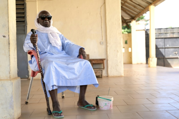 Biram Senghor, fils d'un tirailleur sénégalais tué par l'armée coloniale française en 1944 à Thiaroye, sur la terrasse de sa maison de Diakhao, le 22 novembre 2024 au Sénégal ( AFP / SEYLLOU )