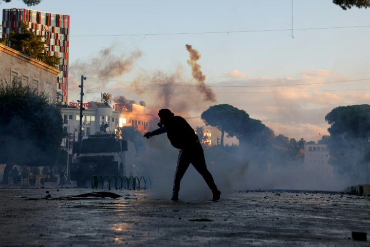 Un protestataire lance une grenade lacrymogène lors d’une manifestation antigouvernementale à Tirana, le 16 octobre 2026 en Albanie ( AFP / Adnan Beci )