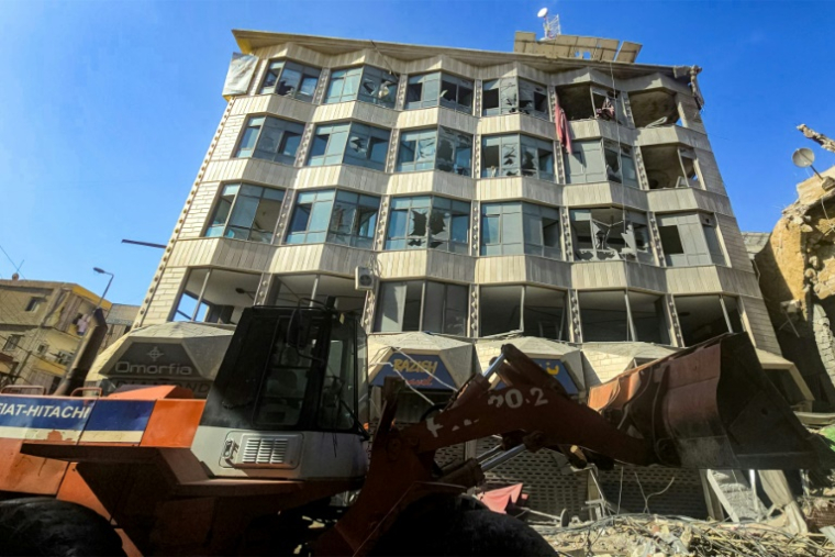 Un bulldozer déblaye des débris et gravats devant un bâtiment endommagé après des bombardements israéliens nocturnes sur la ville de Tyr, dans le sud du Liban, le 16 mai 2026 ( AFP / Kawnat HAJU )