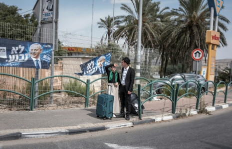 Un couple israélien à côté d'affiches de campagne du Premier ministre israélien Benjamin Netanyahu, dans la colonie israélienne d'Ofra, en Cisjordanie occupée, le 13 octobre 2026 ( AFP / Ilia YEFIMOVICH )