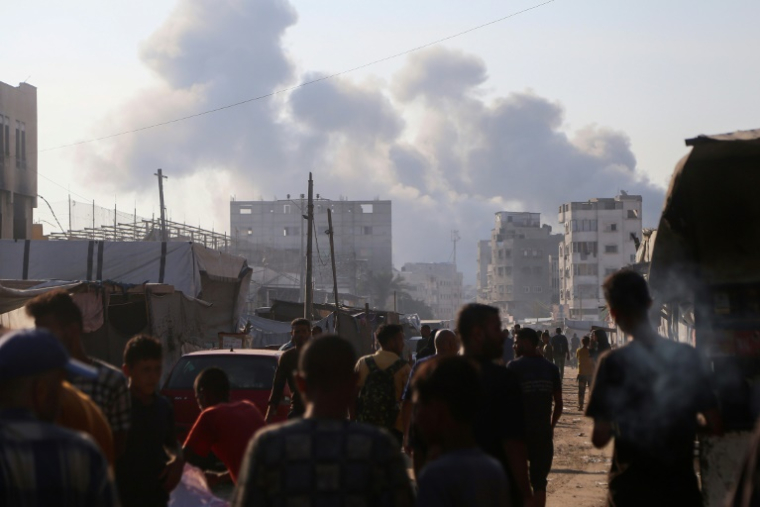 Des Palestiniens déplacés regardent la fumée s'élever au milieu des frappes israéliennes sur le centre de Khan Yunès, dans le sud de la bande de Gaza, le 22 juillet 2025 ( AFP / - )
