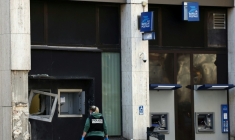 Une membre de la police scientifique inspecte la façade d'un bureau de poste à Roubaix après un braquage à l'explosif, le 12 novembre 2025 ( AFP / Sameer AL-DOUMY )