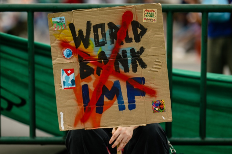 Une pancarte hostile à la Banque mondiale et au FMI lors d'une manifestation à Bangkok ,le 16 octobre 2026 en Thaïlande ( AFP / ANTHONY WALLACE )