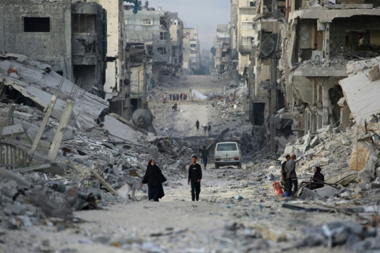 Des Palestiniens marchent au milieu de bâtiments détruits dans la ville de Gaza, le 12 octobre 2025, au troisième jour d'un cessez-le-feu entre Israël et le Hamas palestinien ( AFP / Bashar TALEB )