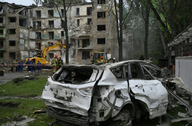 Des sauveteurs déblayent des débris au lendemain d'une frappe de missile russe qui a fait dix morts et éventré un immeuble résidentiel à Kiev, le 24 juin 2025 en Ukraine ( AFP / Genya SAVILOV )