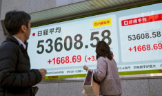 Des passants devant un panneau électronique affichant les cours du Nikkei 225 à la Bourse de Tokyo, le 13 janvier 2026.  ( AFP / Kazuhiro NOGI )