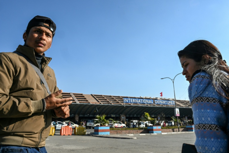 Lalit Bishowkarma (g) attend à l'aéroport international de Katmandou de récupérer la dépouille de son père Rudra Bahadur Kami, mort en Arabie saoudite où il était parti travailler, le 21 janvier 2026 au Népal ( AFP / Prakash MATHEMA )