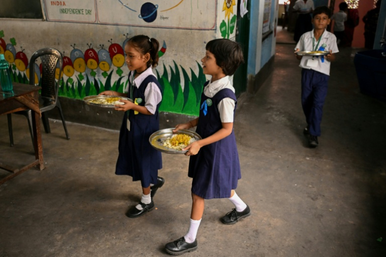 SDes élèves reçoivent un repas de mi-journée dans une école primaire publique de Calcuta, le 9 juillet 2026 en Inde ( AFP / Dibyangshu SARKAR )