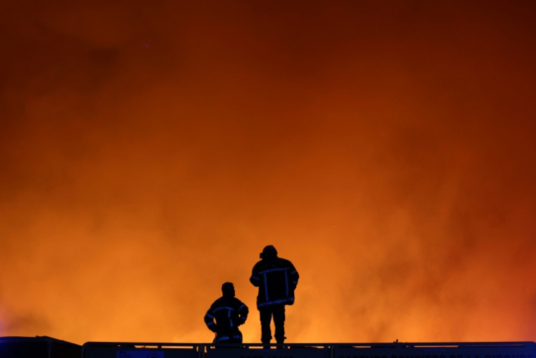 Des pompiers suivent la progression d'un feu de forêt à Le Porge, en Gironde, le 22 juillet 2026  ( AFP / ROMAIN PERROCHEAU )
