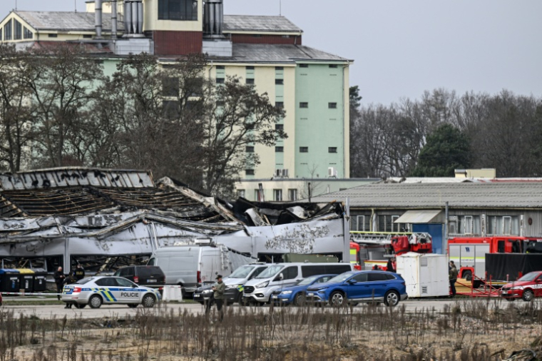 Des pompiers et des enquêteurs sur les lieux d'un incendie dans une usine du fabricant d'armes tchèque LPP Holding, le 20 mars 2026 à Pardubicde, en République tchèque ( AFP / Michal Cizek )