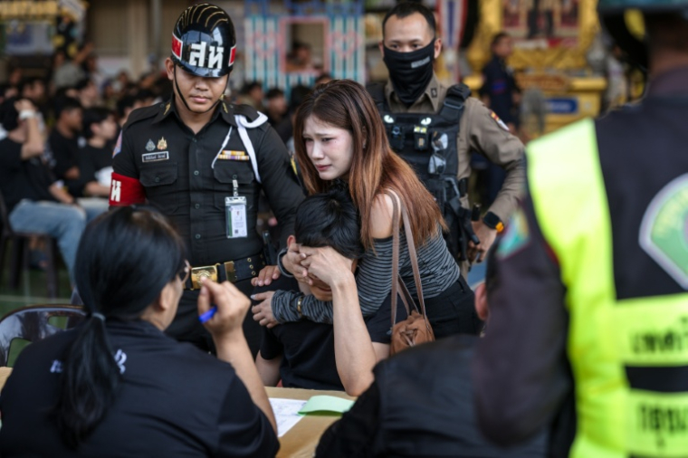 Un homme s'effondre après avoir tiré au sort une carte lui imposant la conscription, le 7 avril 2026 à Bangkok en Thaïlande ( AFP / chanakarn LAOSARAKHAM )