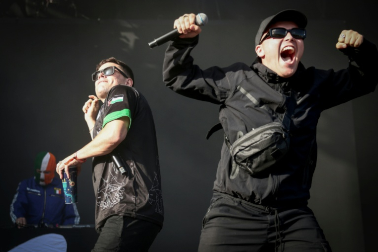 Les rappeurs Naoise O Caireallain (C) et Liam O'Hanna (d), également connu sous le nom de Mo Chara, du trio nord-irlandais Kneecap, sur la scène du festival Rock en Seine à Saint-Cloud, près de Paris, le 24 août 2025 ( AFP / Guillaume BAPTISTE )