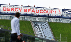Des militants de l'organisation Attac France déploient une banderole sur la salle de spectacles Accor Arena à Paris mardi 2 juin 2026, protestant contre les aides publiques aux multinatinales  ( AFP / Kenzo TRIBOUILLARD )