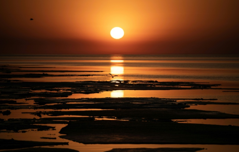 Des blocs de glace dérivent dans le lac Supérieur alors que le soleil se lève à Duluth, aux Etats-Unis, le 13 avril 2023 ( AFP / STEPHEN MATUREN )