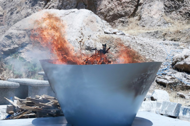 Une grande vasque remplie d’armes de combattants du Parti des Travailleurs du Kurdistan (PKK) en flammes lors d’une cérémonie à Souleimaniyeh, dans la région autonome du Kurdistan irakien, le 11 juillet 2025 ( AFP / Shwan MOHAMMED )