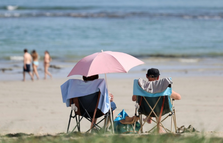 Des personnes sur la plage à Combrit dans le Finistère le 8 avril 2026 ( AFP / Fred TANNEAU )
