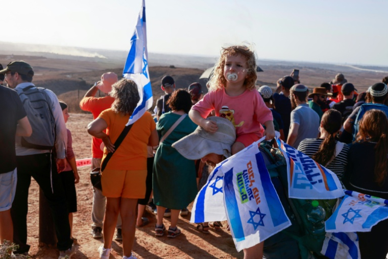Des manifestants israéliens d'extrême droite se rassemblent sur une colline surplombant la bande de Gaza assiégée, près de la barrière frontalière, le 30 juillet 2025 ( AFP / Menahem KAHANA )