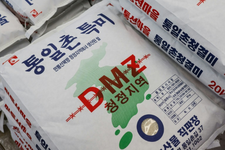Du riz produit dans la zone démilitarisée (DMZ) entre les deux Corées en vente dans le magasin de souvenirs du village sud-coréen de Tongilchon, le 28 mai 2025 ( AFP / ANTHONY WALLACE )