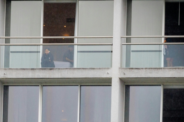 Des membres de l’équipe féminine de football iranienne sur le balcon de leurs chambres dans un hôtel de la Gold Coast, le 9 mars 2026, en Australie ( AFP / Patrick HAMILTON )