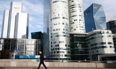 Un homme marche sur l'esplanade de La Défense