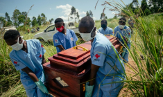 Des membres d'une équipe de la Croix-Rouge congolaise transportent le cercueil d'une femme qui serait décédée des suites de la maladie à virus Ebola lors de son enterrement dans les règles de sécurité dans un cimetière de Bunia, en RDC, le 7 juin 2026. ( AFP / Jospin Mwisha )