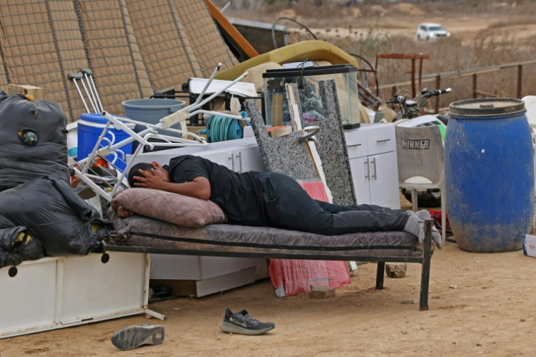 Un homme dort au milieu des affaires sauvées des maisons de la communauté bédouine d'Abu Wadi, détruites sur décision des autorités israéliennes, près de Rahat en Israël le 12 octobre 2026 ( AFP / AHMAD GHARABLI )