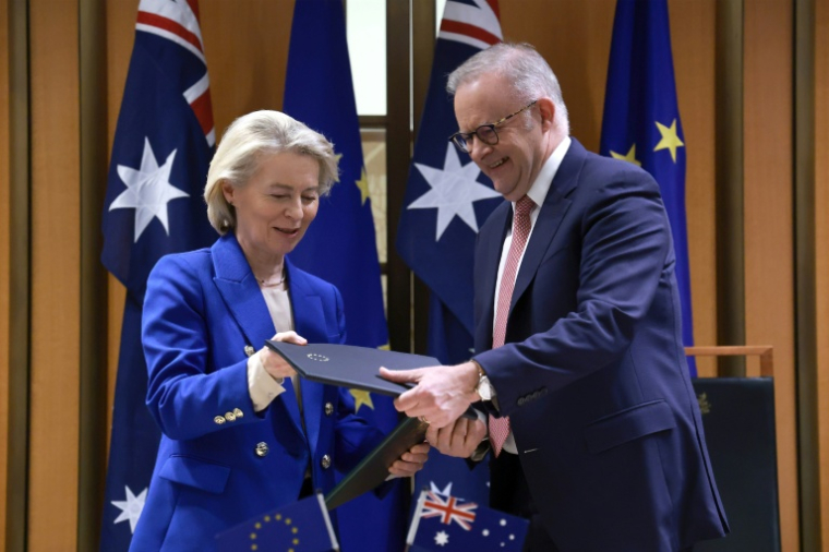 La présidente de la Commission européenne Ursula von der Leyen et le Premier ministre australien Anthony Albanese échangent des copies de l'accord commercial Australie-UE, le 24 mars 2026 à Canberra ( AFP / DAVID GRAY )
