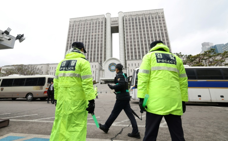 Des policiers à l'entrée du tribunal central de Séoul, le 14 avril 2025, au moment où l'ancien président Yoon Suk Yeol arrive ( KOREA POOL / - )
