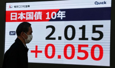 Un homme devant un écran affichant le niveau des obligations d'État japonaises à 10 ans après que la Banque du Japon a annoncé une hausse des taux d'intérêt à Tokyo