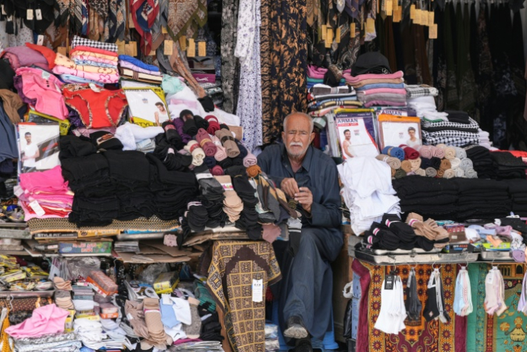 Un vendeur attend des clients dans sa boutique de la ville sainte irakienne de Najaf, qui abrite le sanctuaire de l'imam chiite Ali d'ordinaire très fréquenté par des pèlerins, le 22 avril 2026 ( AFP / Qassem al-KAABI )