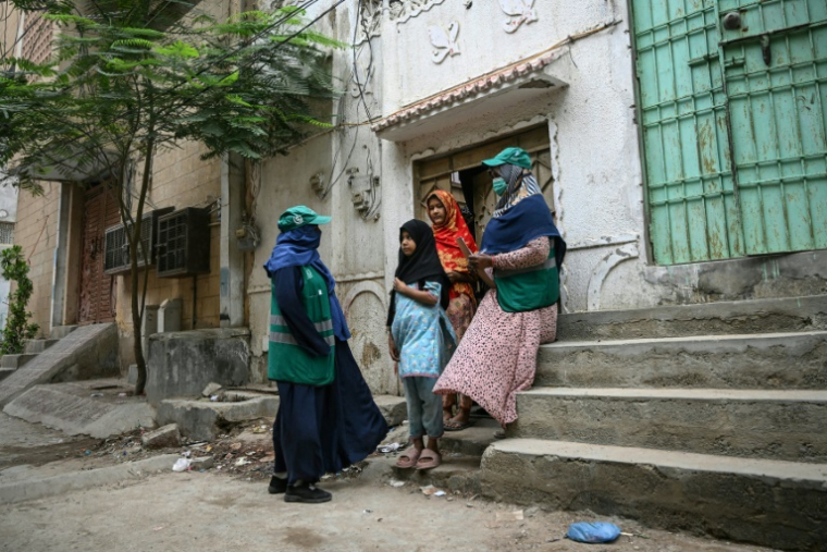 Des agentes de santé parlent à des adolescentes, lors d'une campagne de vaccination porte-à-porte contre le virus du papillome humain (VPH) responsable du cancer du col de l'utérus, le 24 septembre 2025 à Karachi, au Pakistan ( AFP / Rizwan TABASSUM )