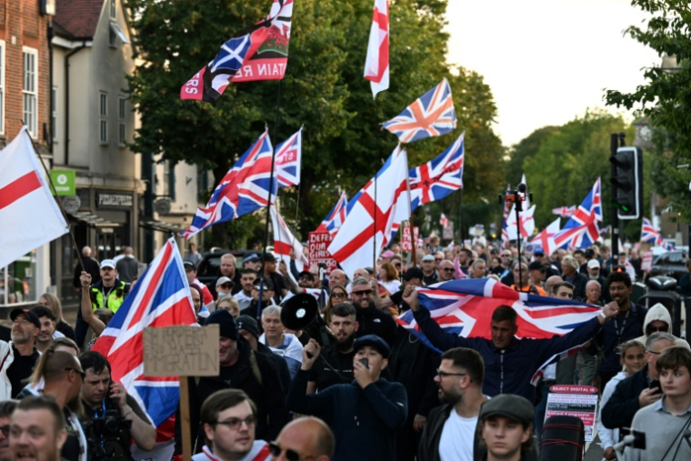 Des manifestants appelant à la fermeture de l'hôtel Bell, qui héberge des demandeurs d'asile, marchent vers les bureaux du conseil municipal d'Epping, au nord-est de Londres, le 31 août 2025 ( AFP / Chris J Ratcliffe )