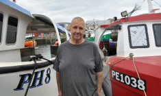 Le pêcheur Brian Tapper entre deux de ses bateaux, dans le port de Plymouth, dans le sud-ouest de l'Angleterre, le 21 août 2025  ( AFP / Joe JACKSON )