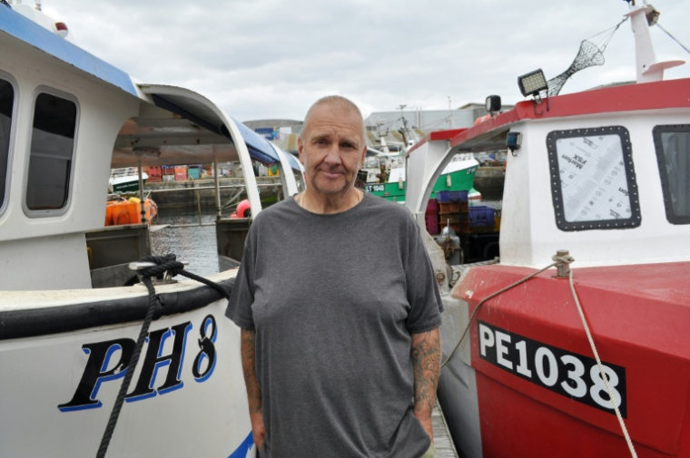 Le pêcheur Brian Tapper entre deux de ses bateaux, dans le port de Plymouth, dans le sud-ouest de l'Angleterre, le 21 août 2025 ( AFP / Joe JACKSON )