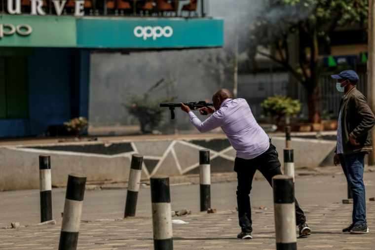 Un policier en civil tire des gaz lacrymogènes sur des manifestants protestant contre la hausse du prix des carburants, le 18 mai à Nairobi ( AFP / SIMON MAINA )