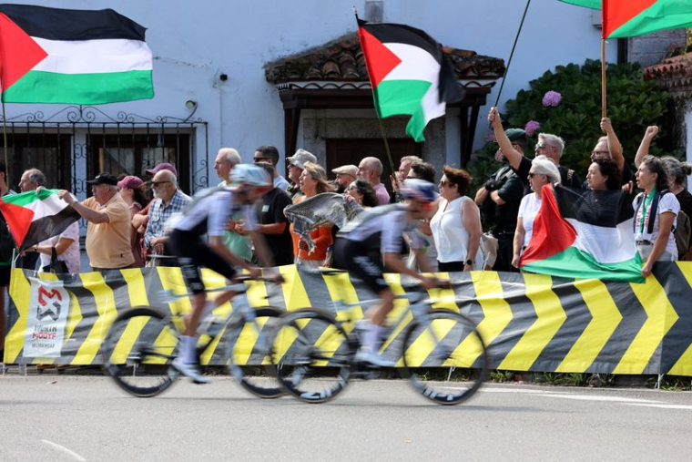 Vuelta a Espana -Des coureurs passent devant des manifestants portant des drapeaux palestiniens