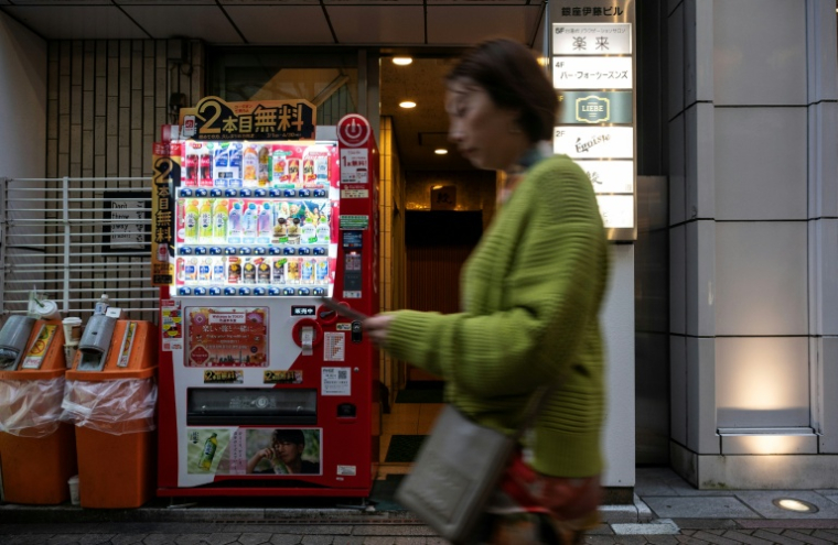 Une femme passe devant un distributeur automatique, le 7 avril 2026 à Tokyo  ( AFP / Andrew CABALLERO-REYNOLDS )