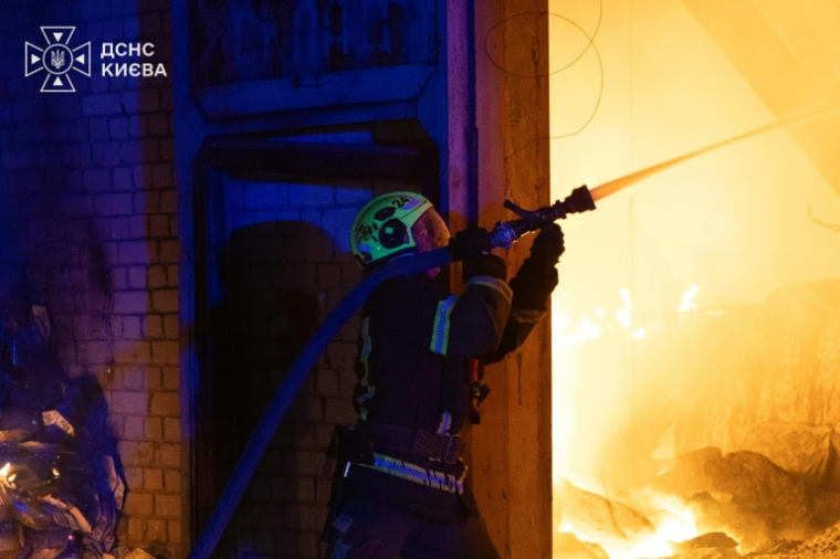 Photo prise et diffusée le 8 août 2026 par le service d’État ukrainien des situations d’urgence montrant un pompier luttant contre un incendie après des frappes de missiles balistiques russes à Kiev ( Ukrainian State Emergency Service / handout )