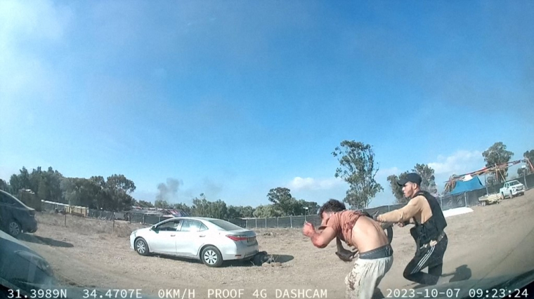 Un membre du Hamas armé maintient un homme au festival Supernova, dans le désert du Néguev en Israël lundi.  ( SOUTH FIRST RESPONDERS / - )